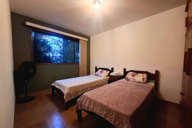 Quarto com duas camas de solteiro e ventilador
