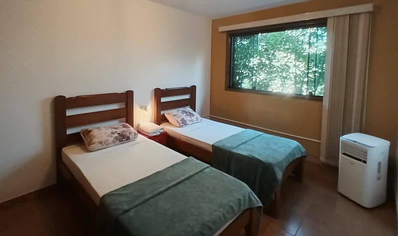 Quarto com duas camas de solteiro e ar-condicionado portátil
